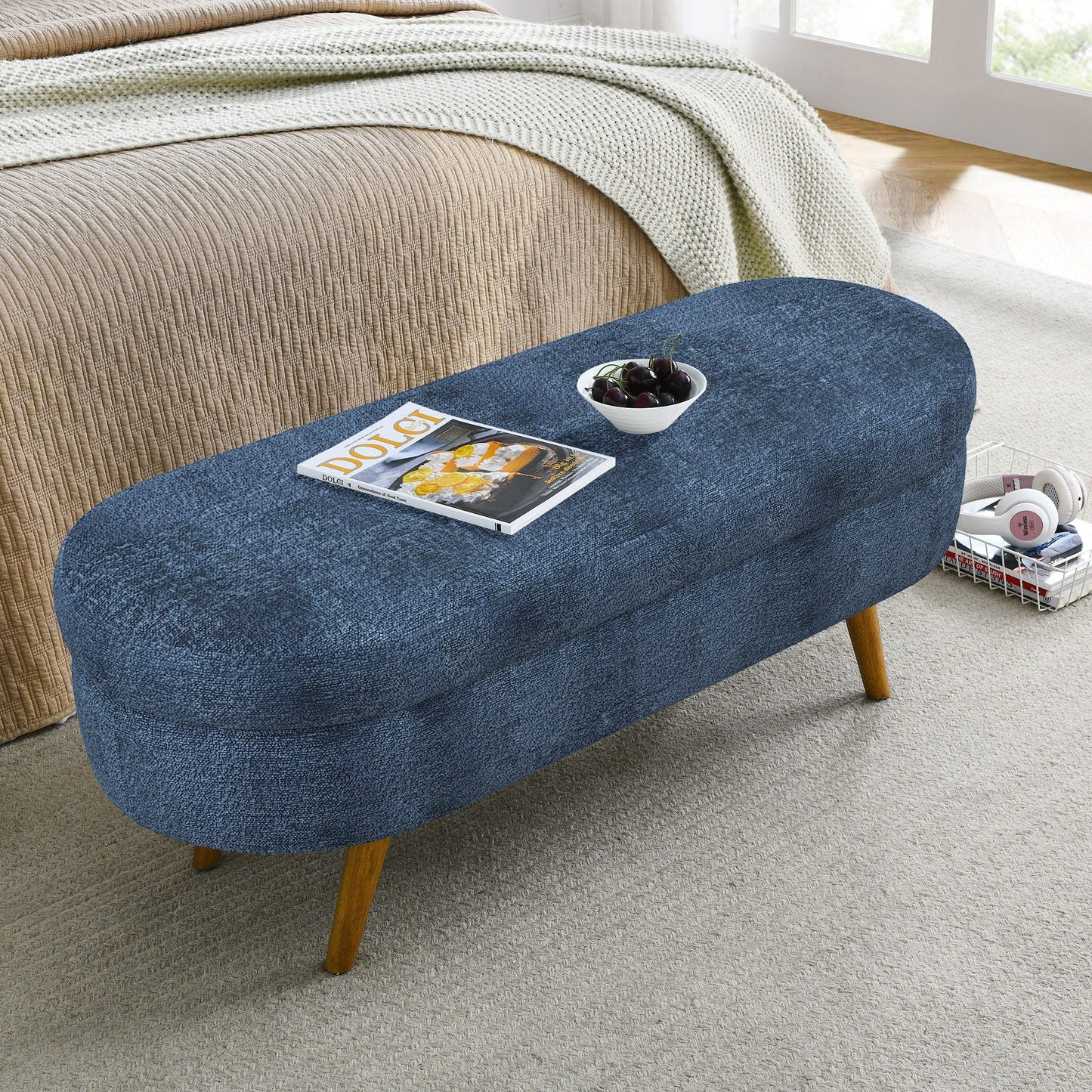 Blue modern oval storage bench with rubber wood legs at bed foot beige bedspread and throw on Tampa Home & Garden Store