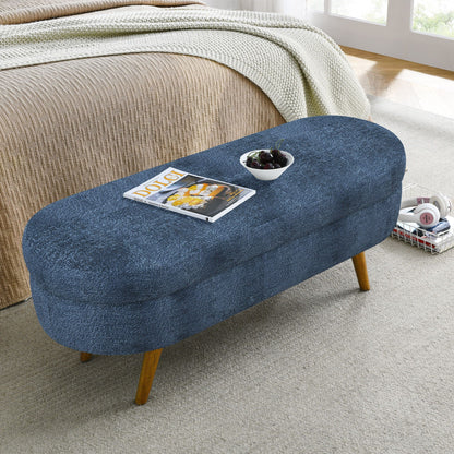 Blue modern oval storage bench with rubber wood legs at bed foot beige bedspread and throw on Tampa Home & Garden Store