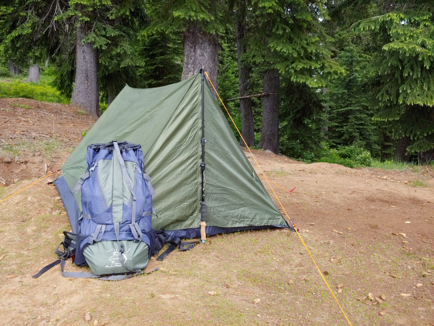 65 Liter Backpacking Pack River Country Gear with blue backpack beside green tent in woods on Tampa Home & Garden Store