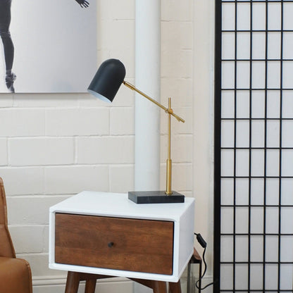 Lumora table lamp black shade with brass stem on a square black base atop white nightstand on Tampa Home & Garden Store