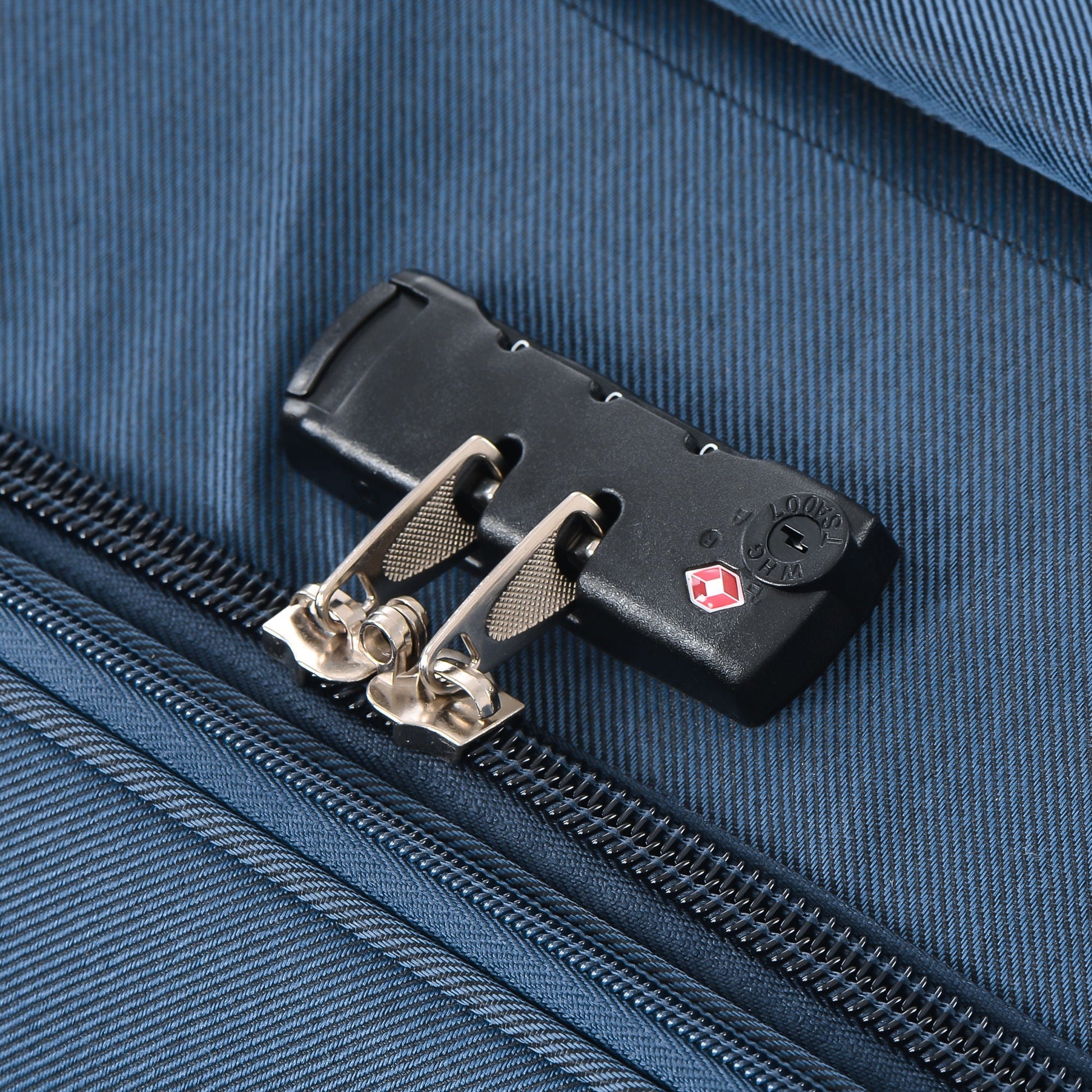 Softside luggage lock detail on dark blue fabric with metal zippers on Tampa Home & Garden Store
