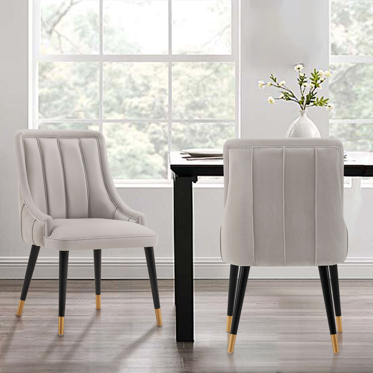 Pair of Eda dining arm chairs with stitched light gray upholstery and black legs on Tampa Home & Garden Store