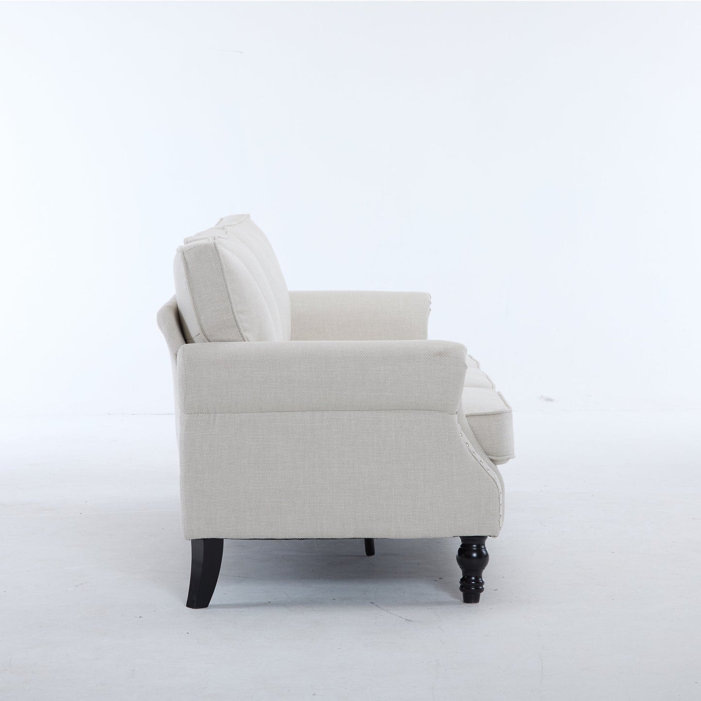 Beige fabric rolled-arm chair with nailhead trim and dark wood legs on Tampa Home & Garden Store