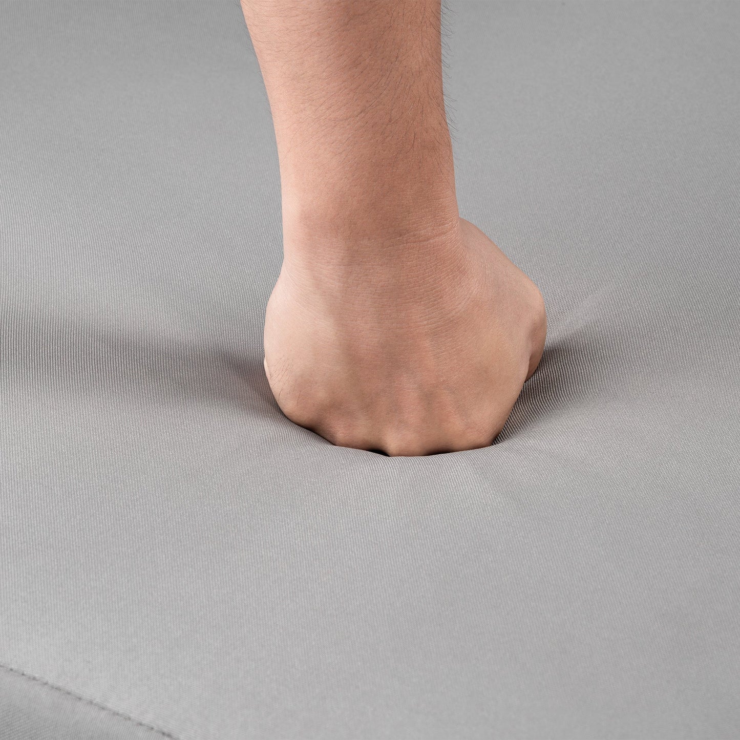 Bare foot resting on gray upholstery fabric with visible stitches on Tampa Home & Garden Store
