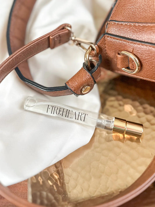 Perfume Fireheart Travel by In the Wick; mini bottle with gold cap beside brown leather bag on Tampa Home & Garden Store