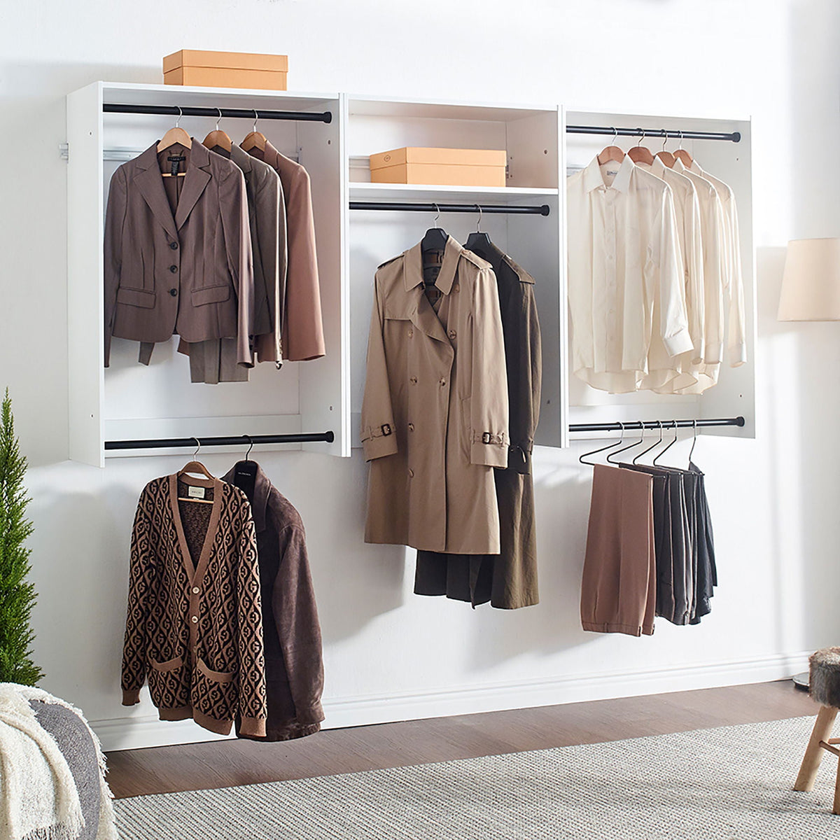 Wall mounted wood closet system with three white modular wardrobes and brown coats on Tampa Home & Garden Store