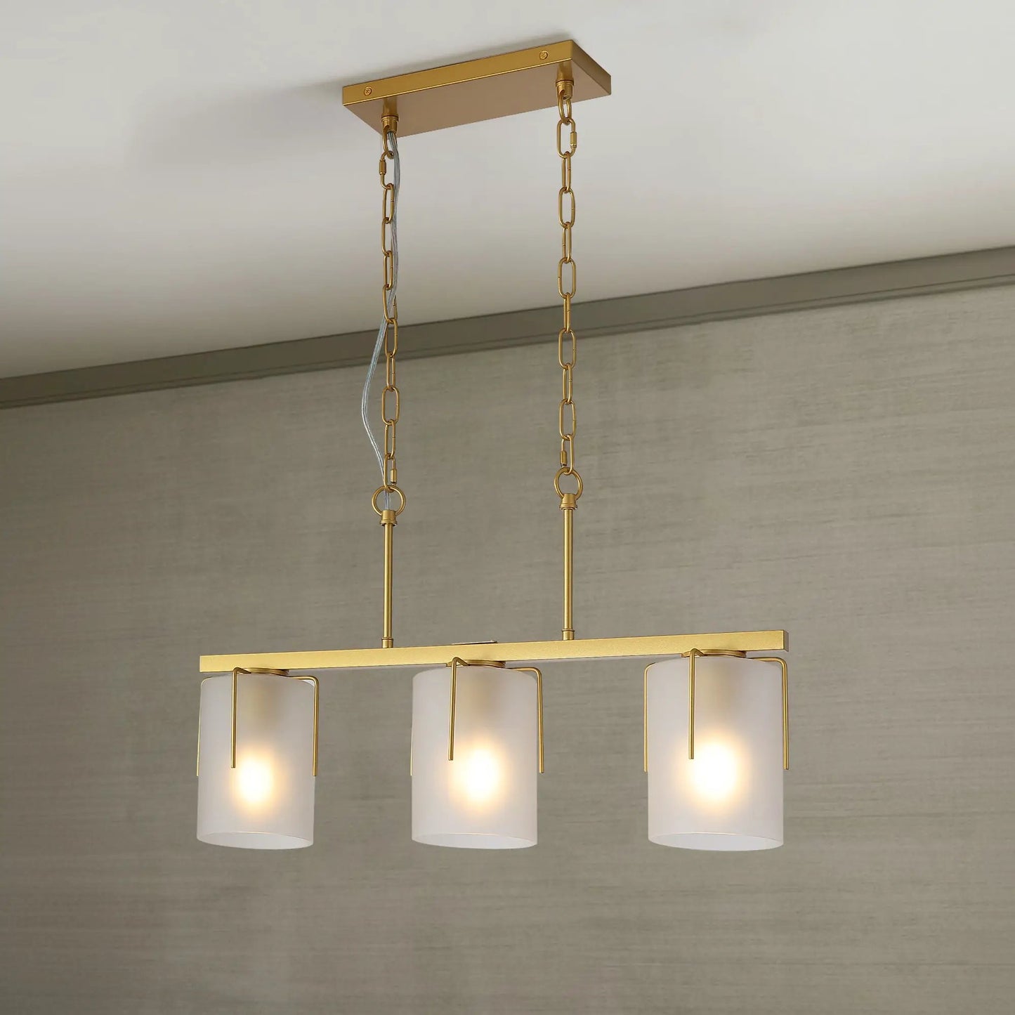 Adjustable cylindrical pendant light in gold brass with three frosted glass shades on gold chains on Tampa Home & Garden Store