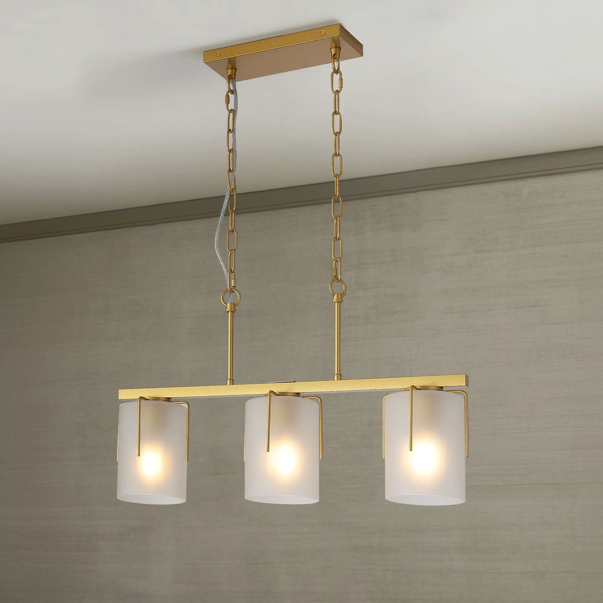 Adjustable cylindrical pendant light in gold brass with three frosted glass shades on gold chains on Tampa Home & Garden Store
