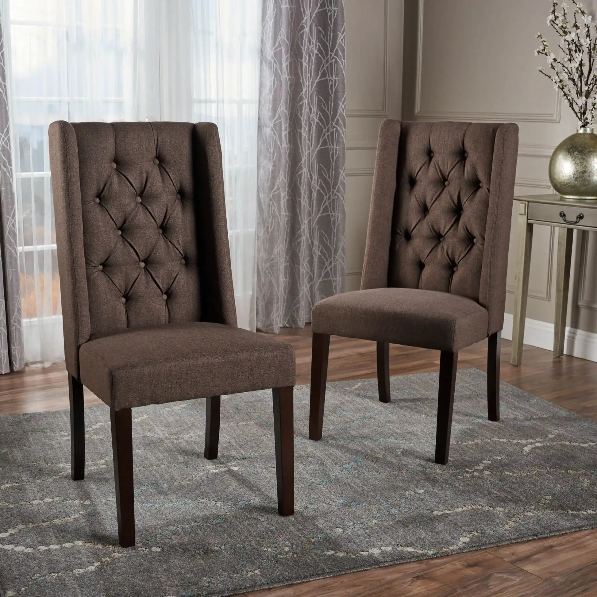 Two brown tufted dining chairs with high backs and dark wood legs in a modern dining area on Tampa Home & Garden Store