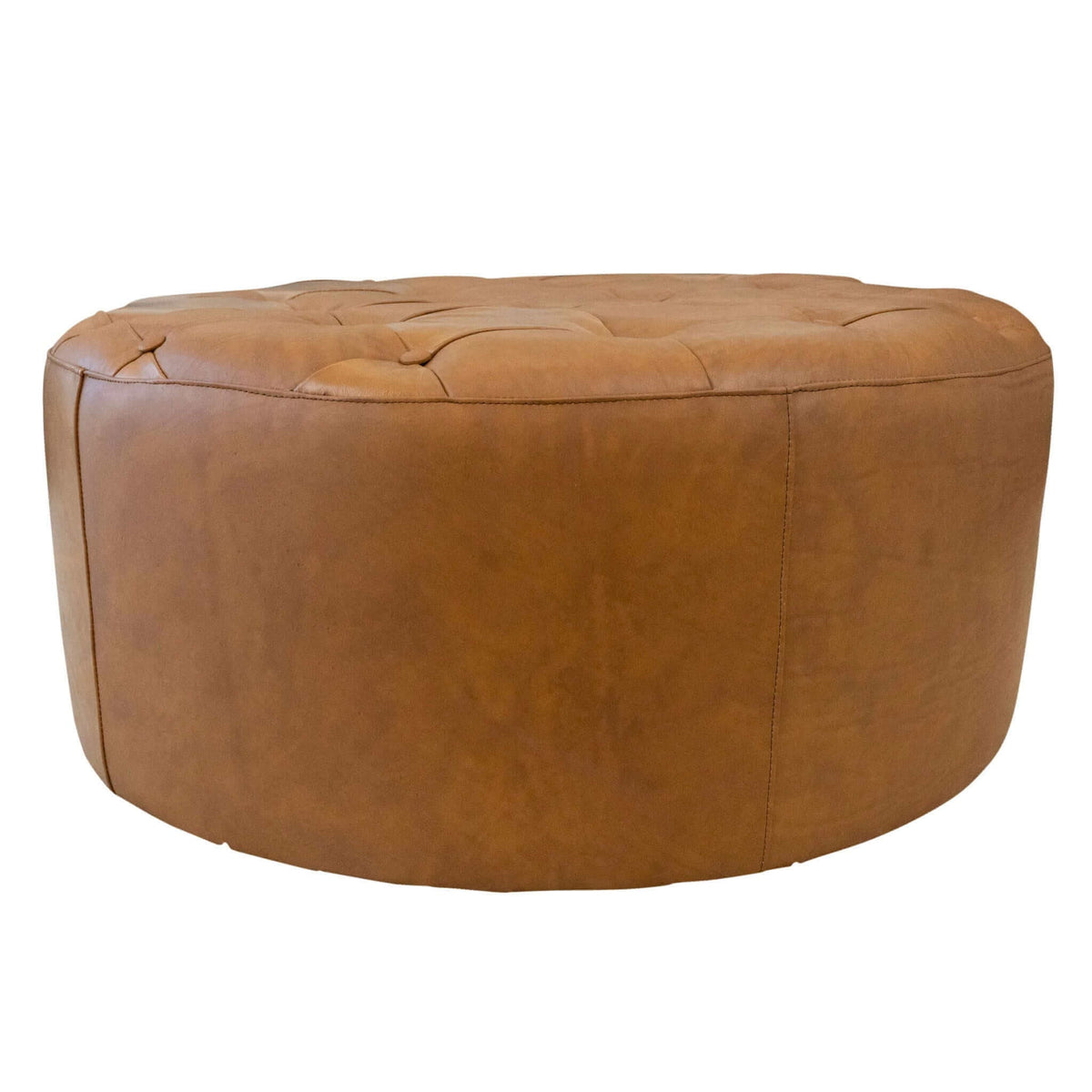 Light tan leather ottoman with tufted top and rounded sides on Tampa Home & Garden Store