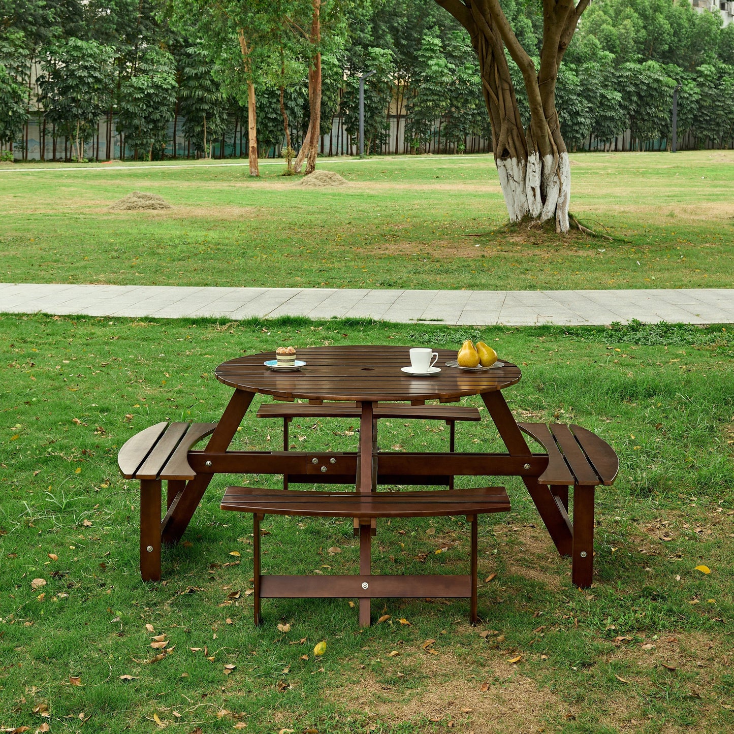 Outdoor 8 Person Round Picnic Table with Built-In Benches in brown wood placed on grassy park lawn on Tampa Home & Garden Store