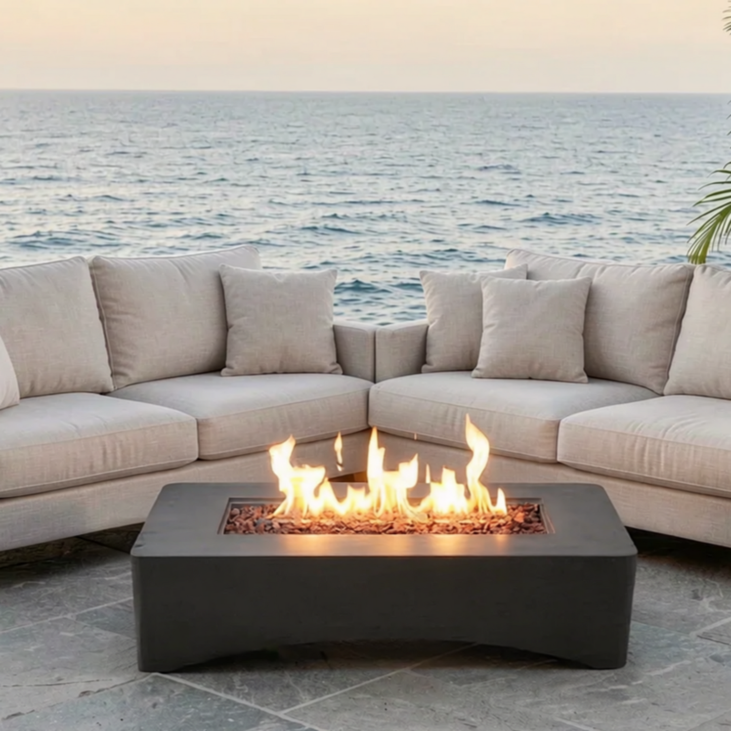 56 inch rectangular propane fire pit table with flames, dark gray base beside beige seating on Tampa Home & Garden Store