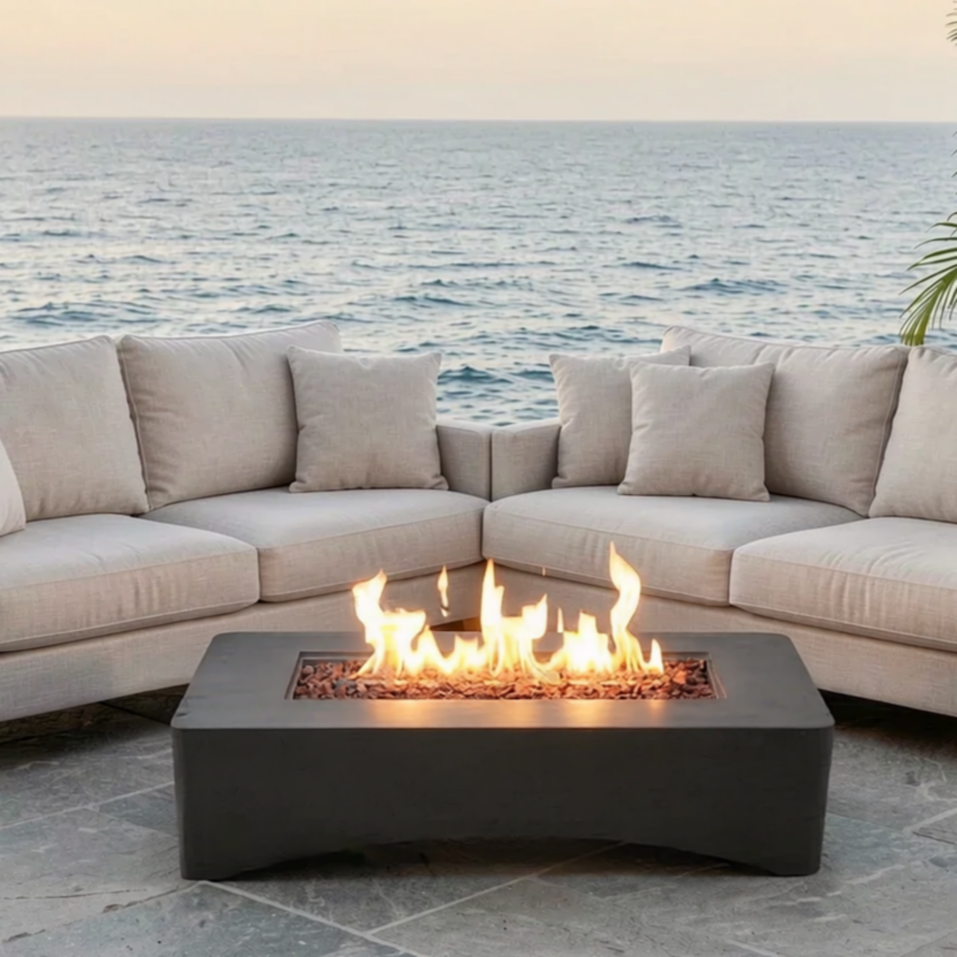 56 inch rectangular propane fire pit table with flames, dark gray base beside beige seating on Tampa Home & Garden Store