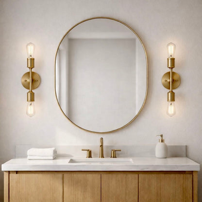 Reverie double lights bathroom wall sconces with gold finish and clear bulbs flanking mirror on Tampa Home & Garden Store