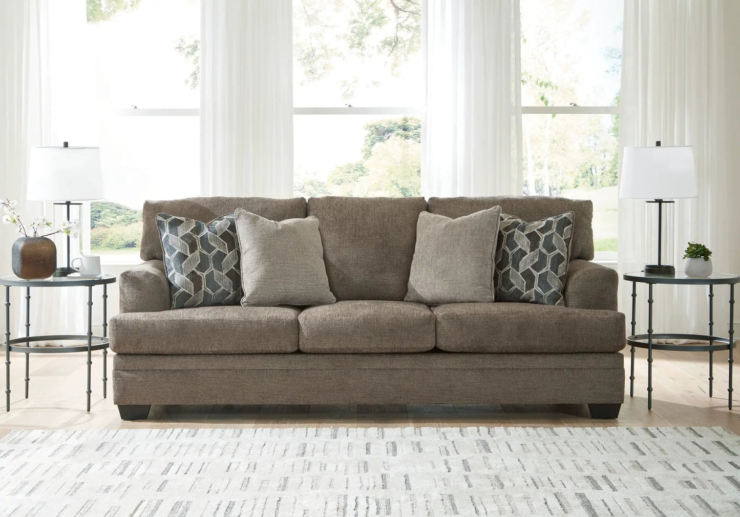 Stonemeade stationary sofa in taupe fabric with two geometric pillows on Tampa Home & Garden Store