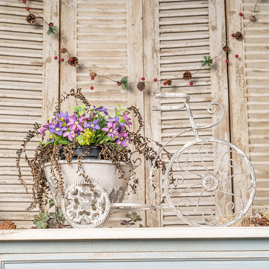 Whitewashed rustic bicycle metal wire wall planter basket with purple flowers on Tampa Home & Garden Store