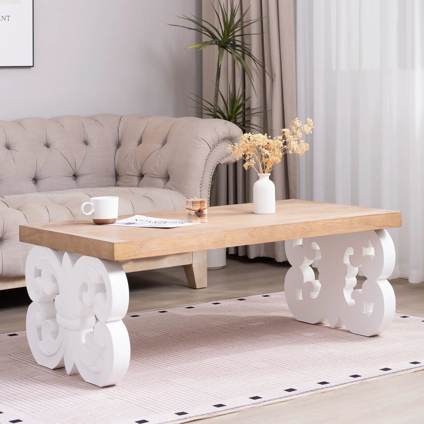 Ornate scroll-base coffee table with natural wood top and white carved base in living room on Tampa Home & Garden Store