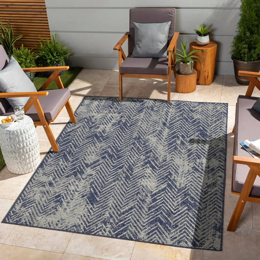 Sunshine Indoor/Outdoor Area Rug navy gray chevron on a patio with wooden armchairs on Tampa Home & Garden Store