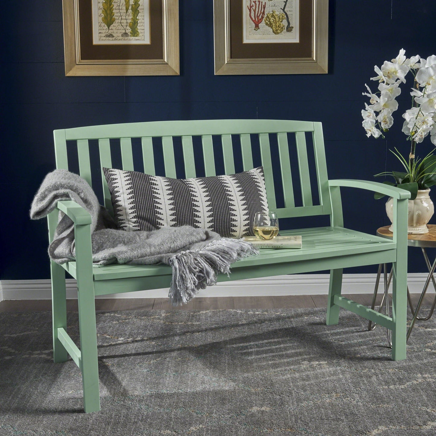 Farmhouse Loja outdoor bench in mint green with slatted back gray throw and geometric pillow on Tampa Home & Garden Store