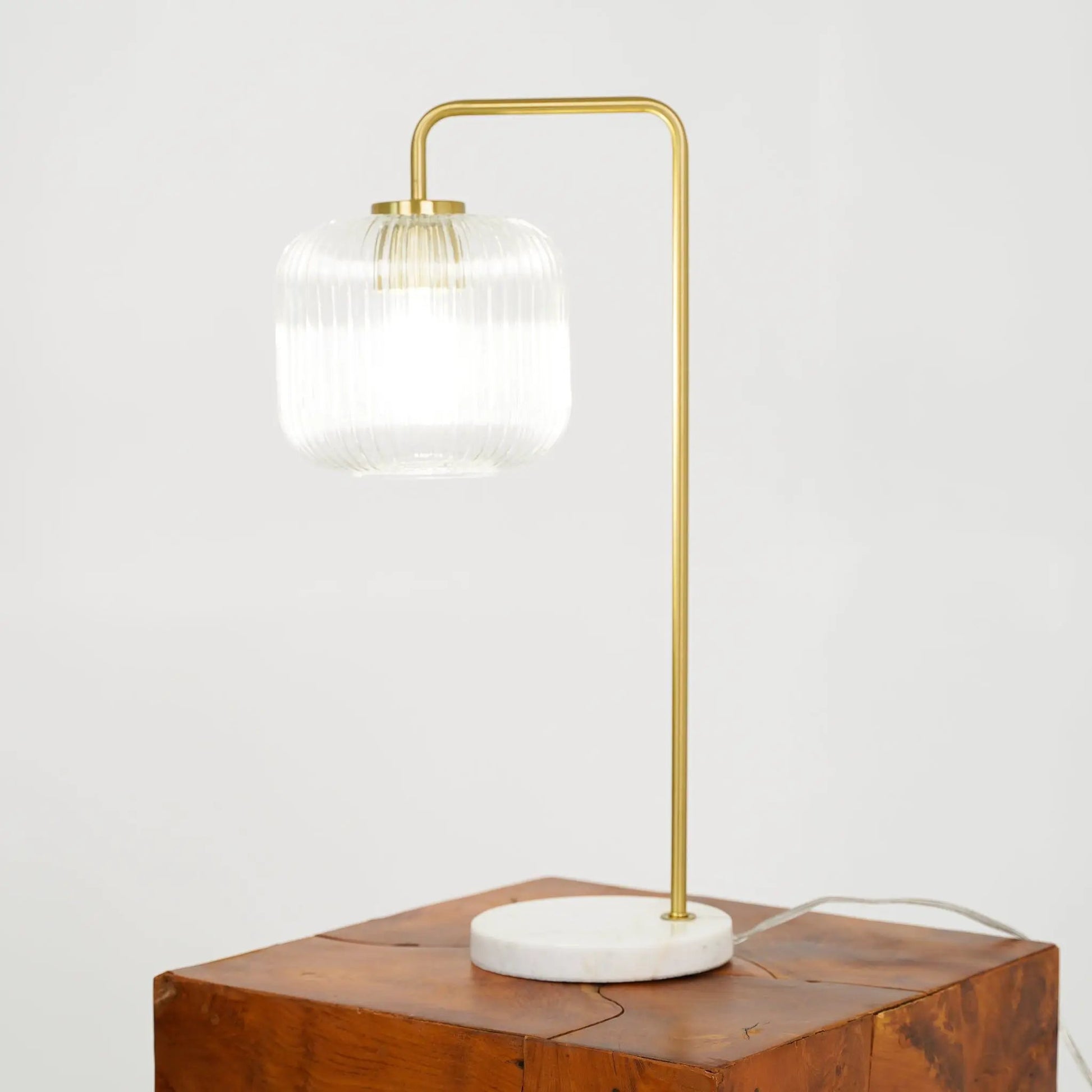 Haven table lamp with gold frame and ribbed clear glass shade on white marble base on Tampa Home & Garden Store
