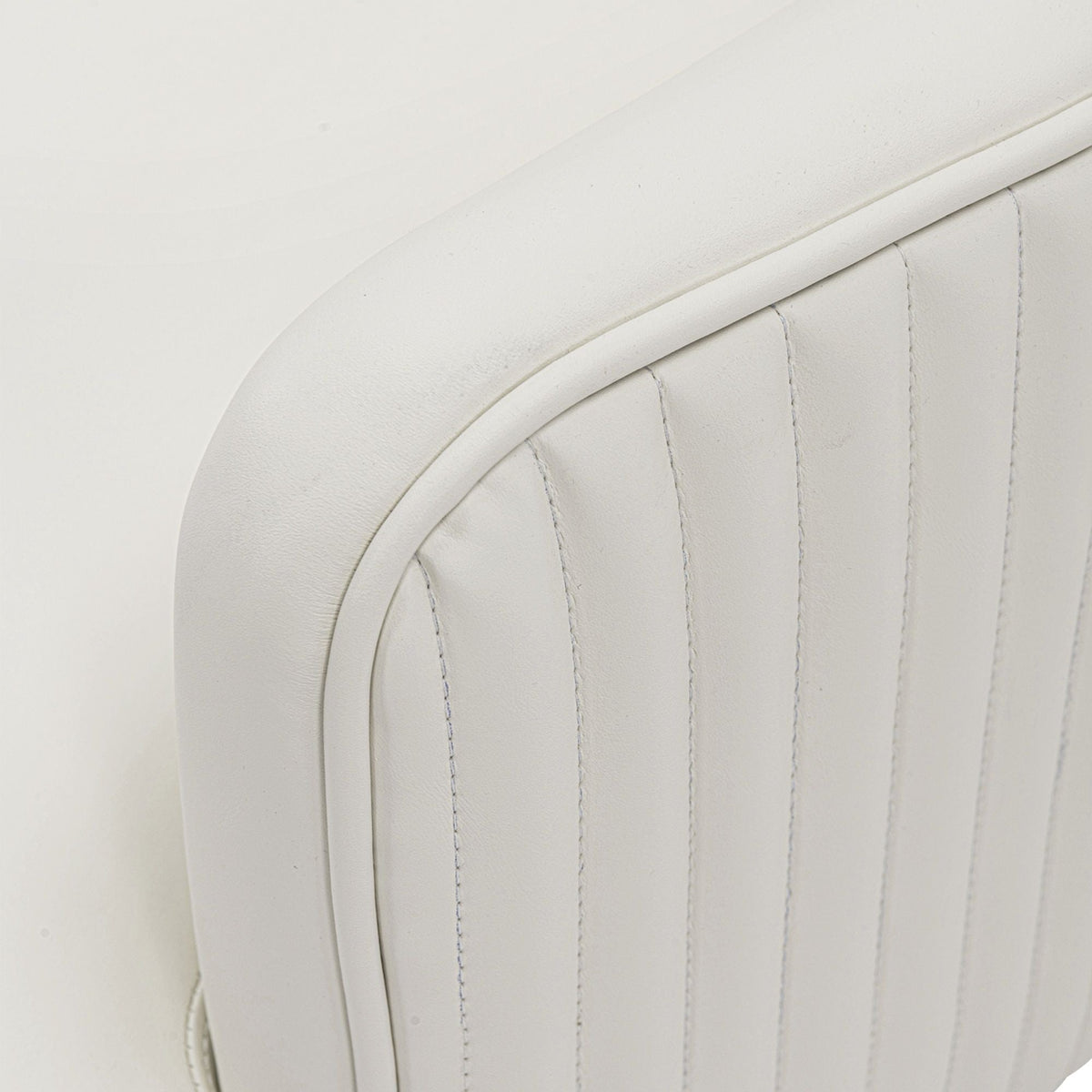 Arm chair close-up in white leather upholstery with curved stitched seams on Tampa Home & Garden Store