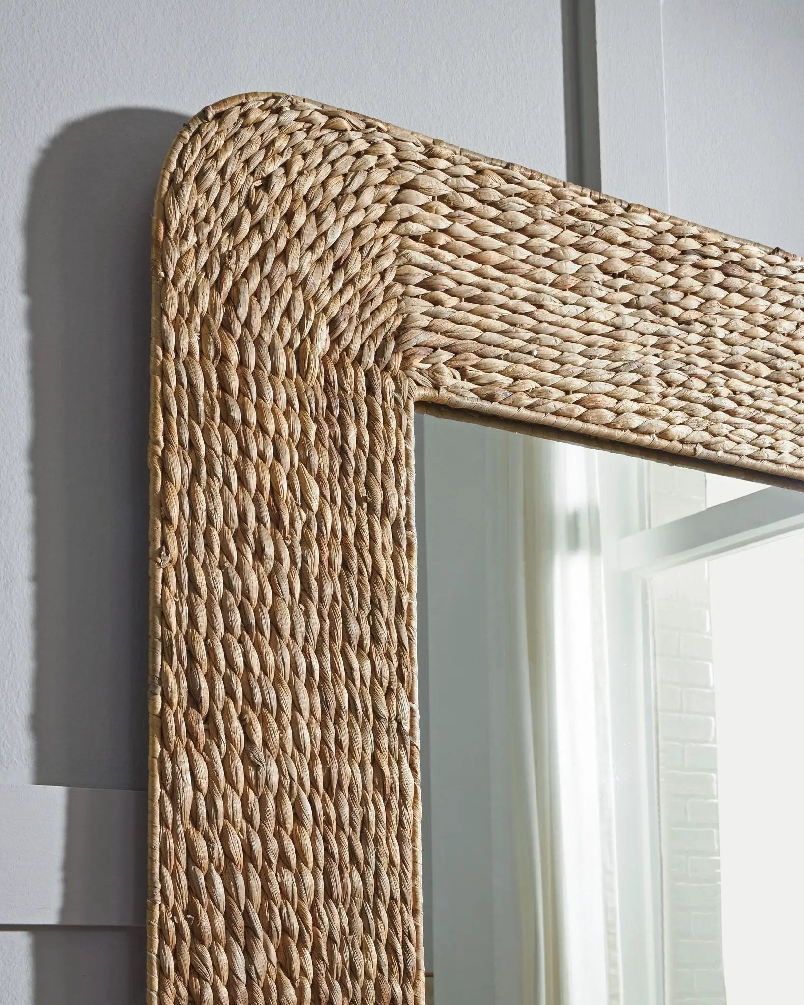 Norigan floor mirror with natural woven rattan frame, close-up of rounded corner on Tampa Home & Garden Store
