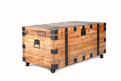 Trunk coffee table in natural wood with black metal hardware and four wheels for storage on Tampa Home & Garden Store