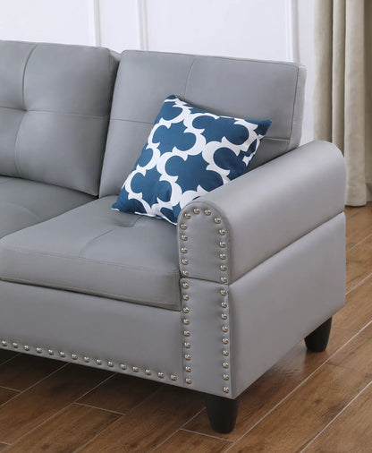 Irine gray sectional sofa in faux leather, blue patterned pillow, studded arms on Tampa Home & Garden Store