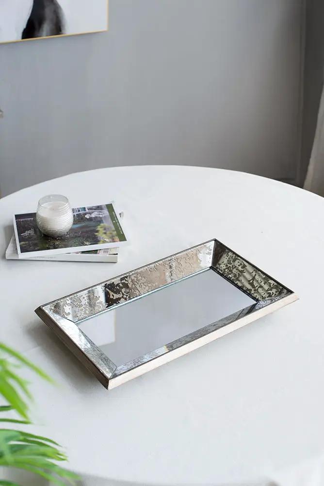 Antique rectangle mirrored display tray with floral accents in a silver hammered frame on a round table on Tampa Home & Garden Store