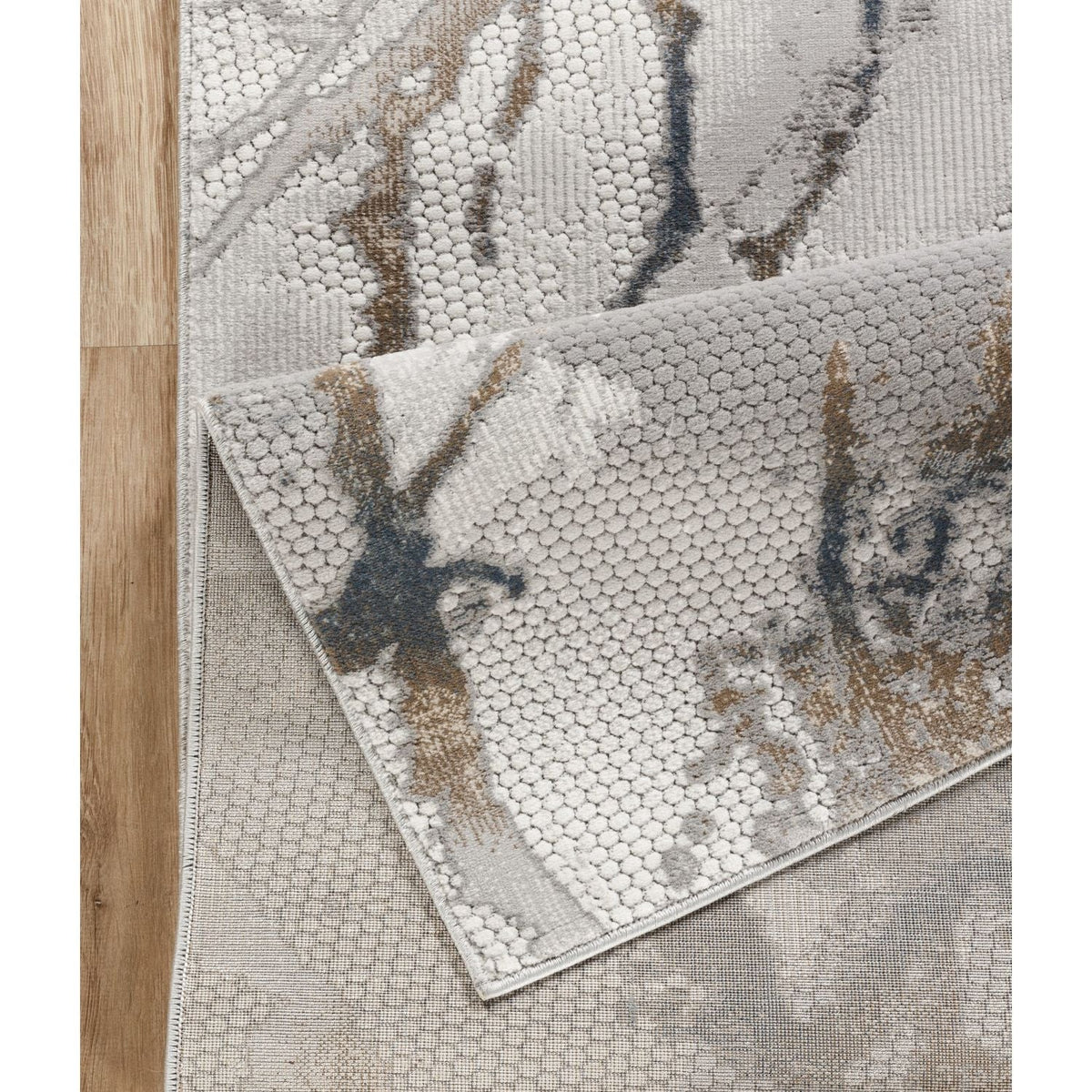 Geometrix Area Rug in Gray with 3D textured geometric pattern layered on wood floor on Tampa Home & Garden Store