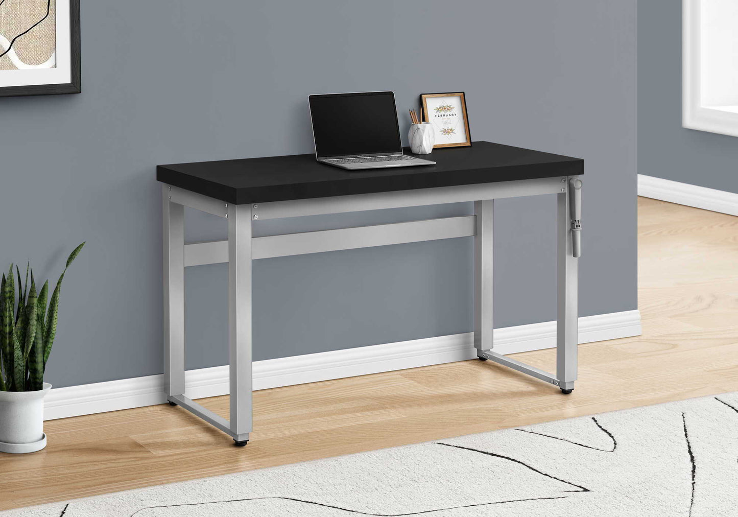 Adjustable standing computer desk with black top and silver frame laptop and calendar on surface on Tampa Home & Garden Store