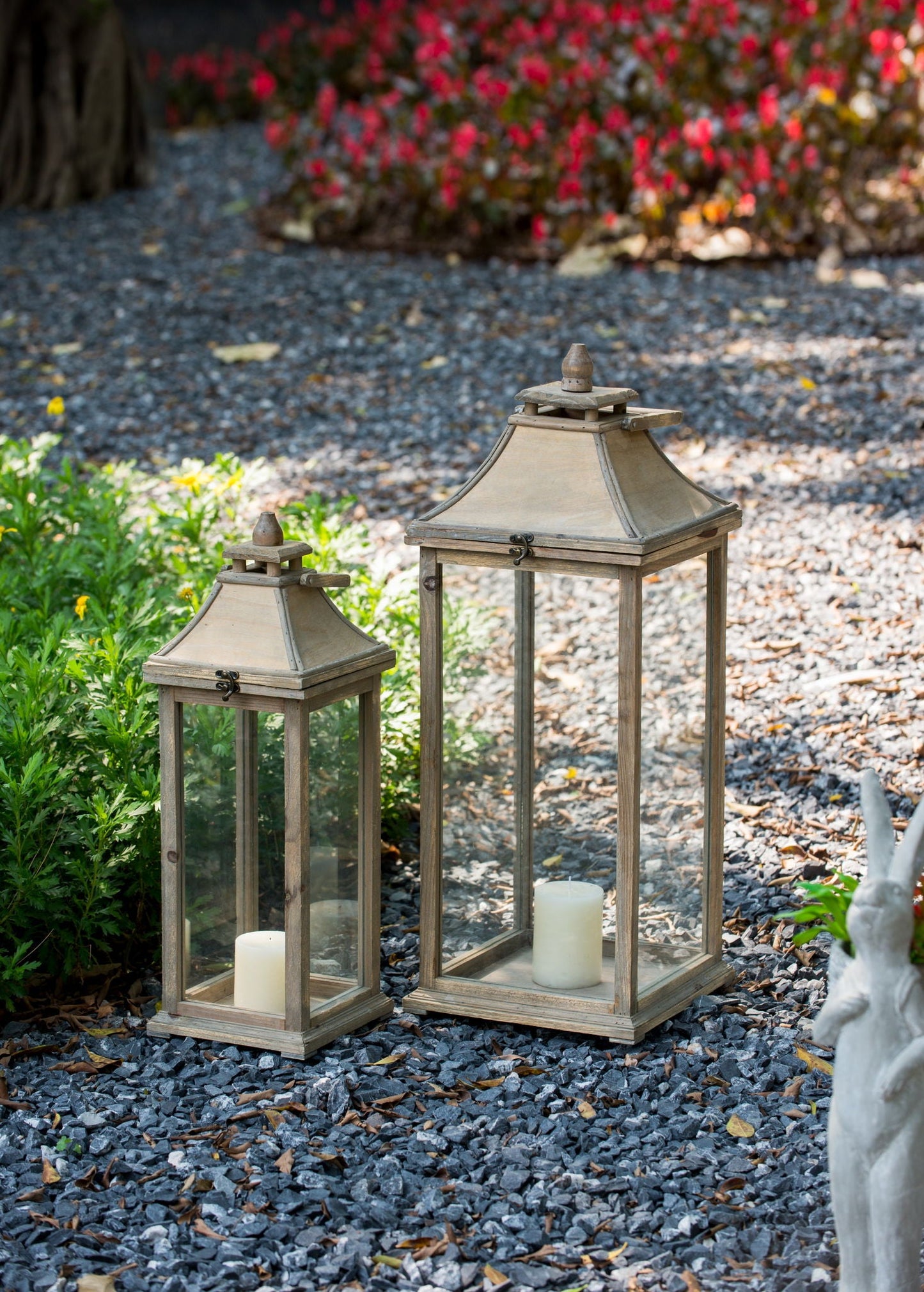 Ivory candle lanterns by HouseOfZazla in a trio with glass panels on a gravel garden path on Tampa Home & Garden Store