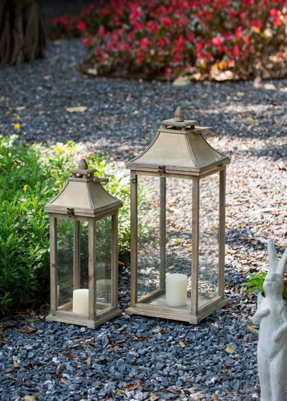 Ivory candle lanterns by HouseOfZazla in a trio with glass panels on a gravel garden path on Tampa Home & Garden Store