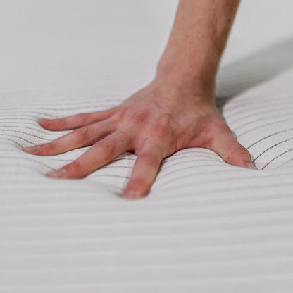 Memory foam mattress surface being pressed by hand on white striped cover copper infused cooling on Tampa Home & Garden Store