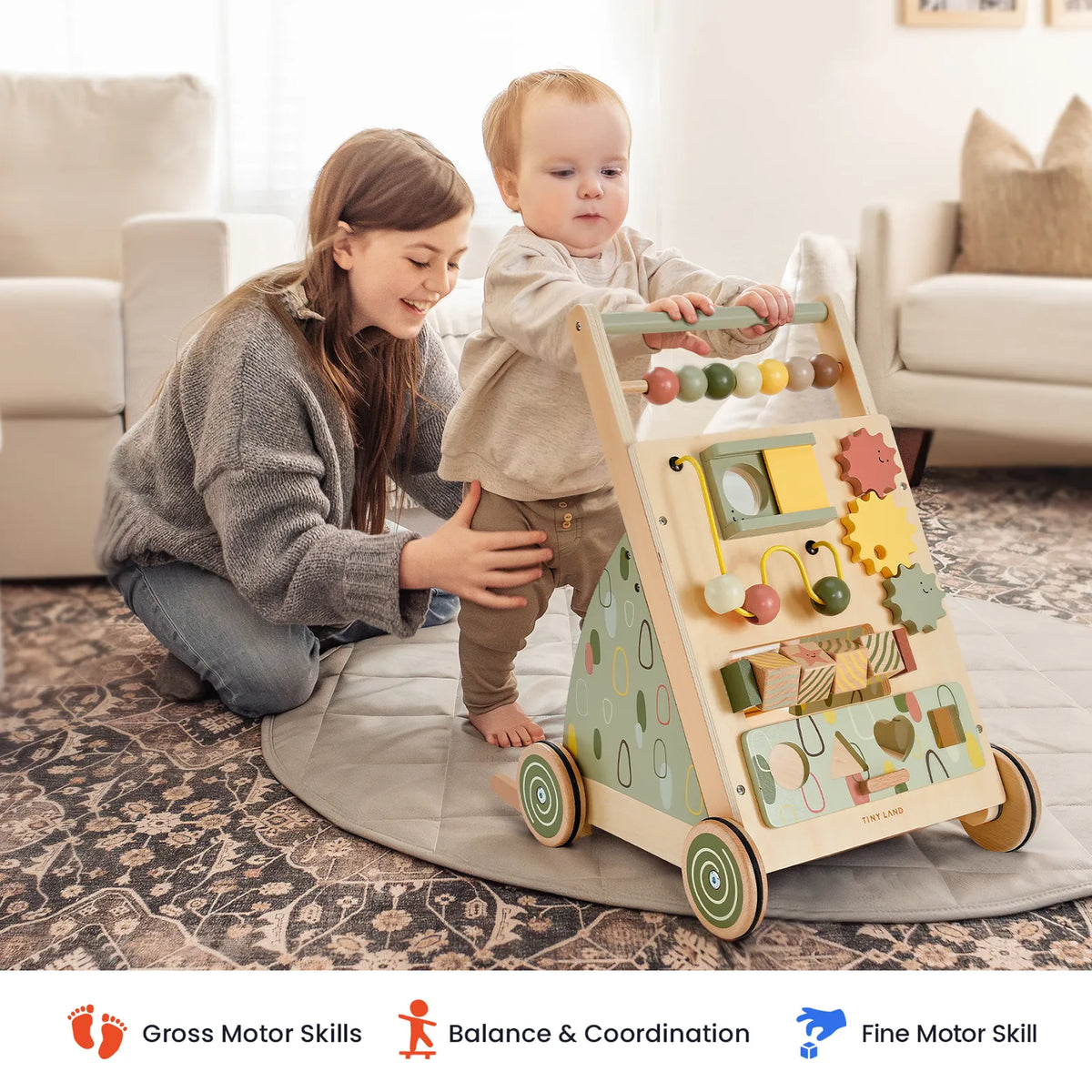 Tiny Land Sage Green Wooden Baby Walker with bead maze panels; caregiver helps toddler indoors on Tampa Home & Garden Store