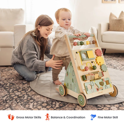 Tiny Land Sage Green Wooden Baby Walker with bead maze panels; caregiver helps toddler indoors on Tampa Home & Garden Store
