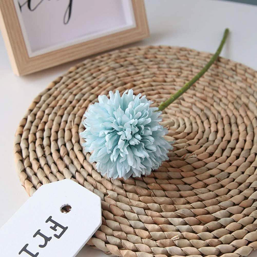Artificial chrysanthemum ball bouquet in pale blue with a green stem on a woven round placemat on Tampa Home & Garden Store
