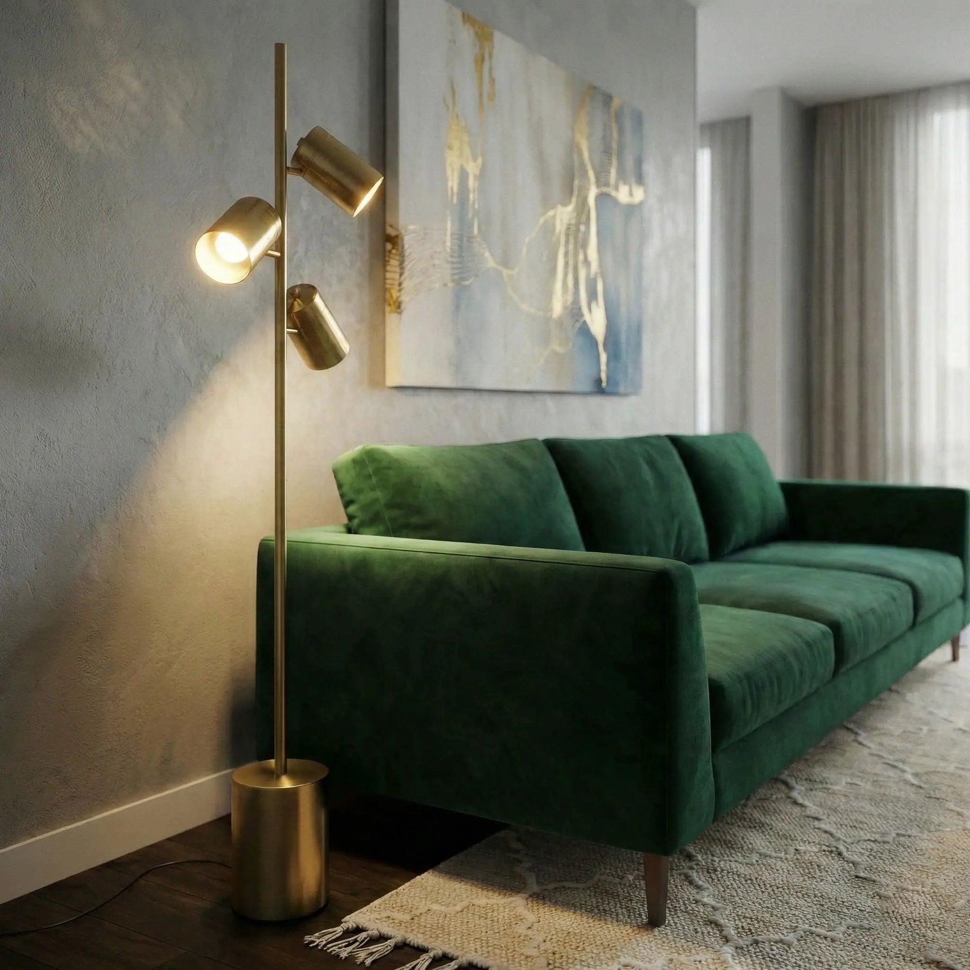 Harmony gold floor lamp with triple spotlights on a block base beside a gray wall and green sofa on Tampa Home & Garden Store