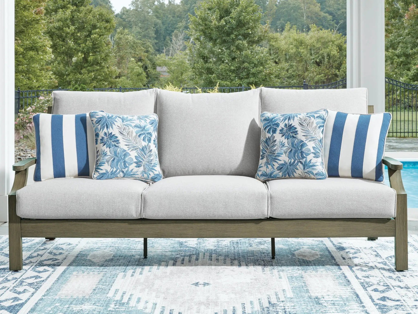 Rainier Ranch sofa with beige cushions; blue leaf-pattern and blue striped pillows on Tampa Home & Garden Store