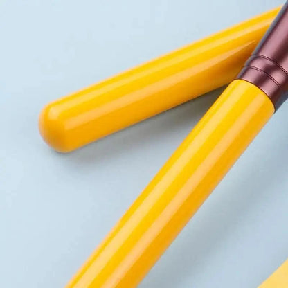 Two yellow makeup brush handles with brown ferrules on Tampa Home & Garden Store