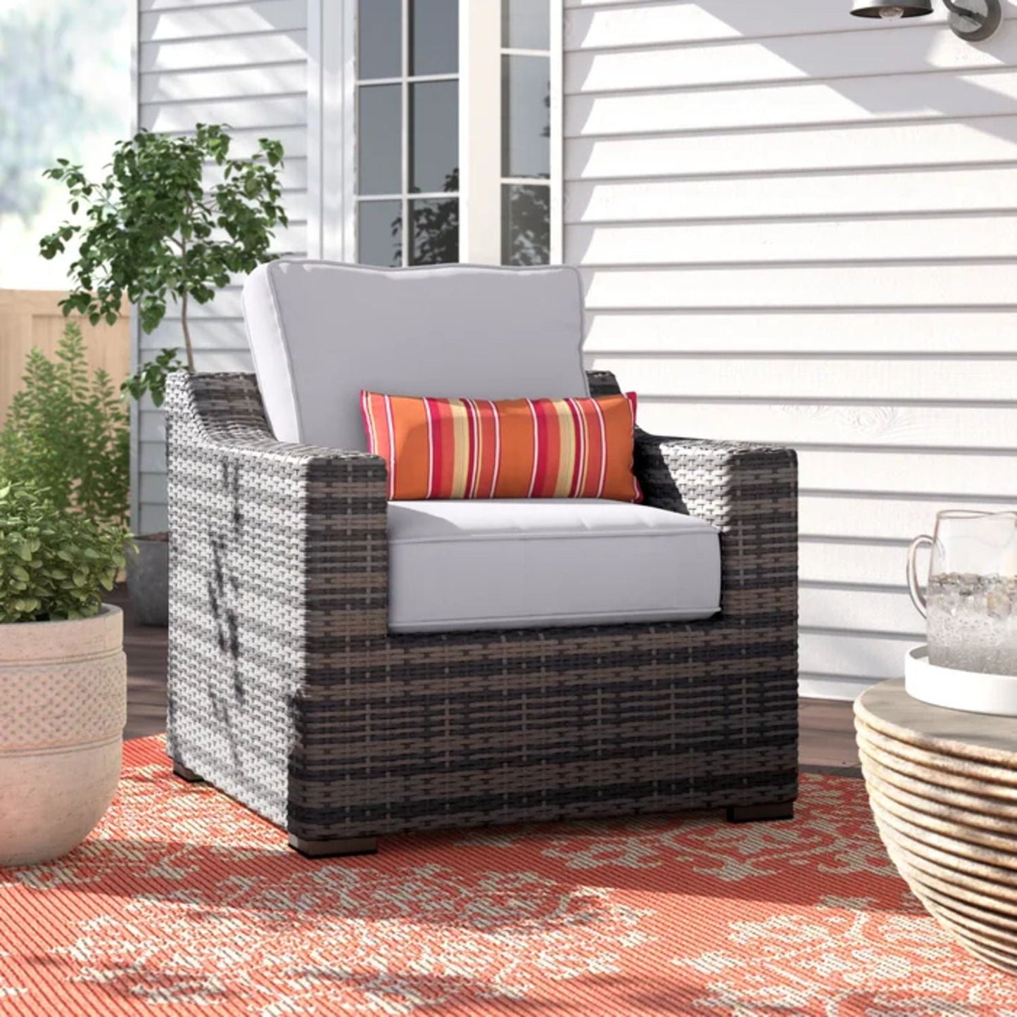 Patio chair with cushions, modern wicker arm chair in gray with orange striped pillow on Tampa Home & Garden Store