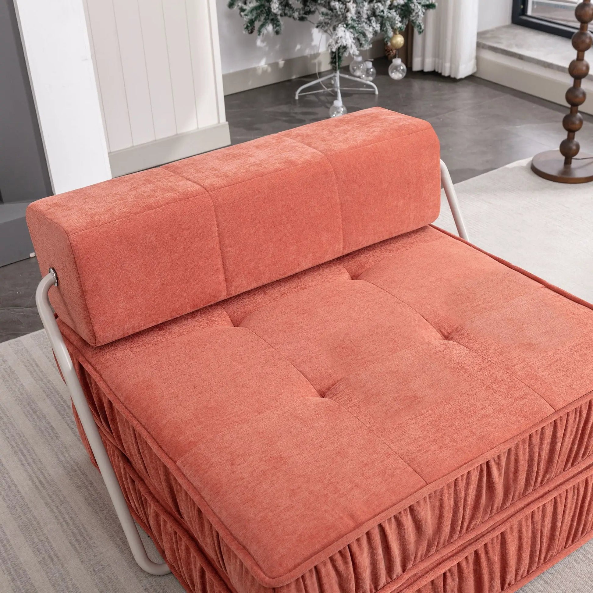 Folding futon chair in coral-orange fabric with removable back cushion and metal frame on Tampa Home & Garden Store