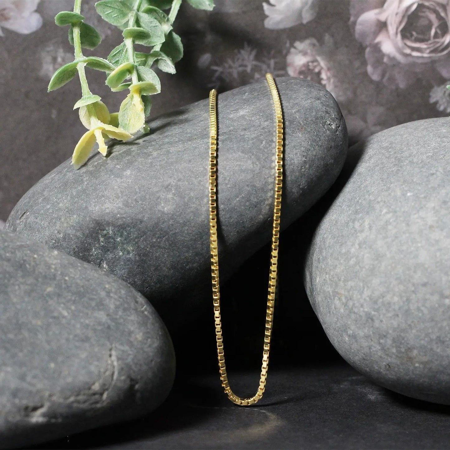 14k Yellow Gold Classic Box Chain Necklace 1.4mm draped over smooth gray stones on Tampa Home & Garden Store