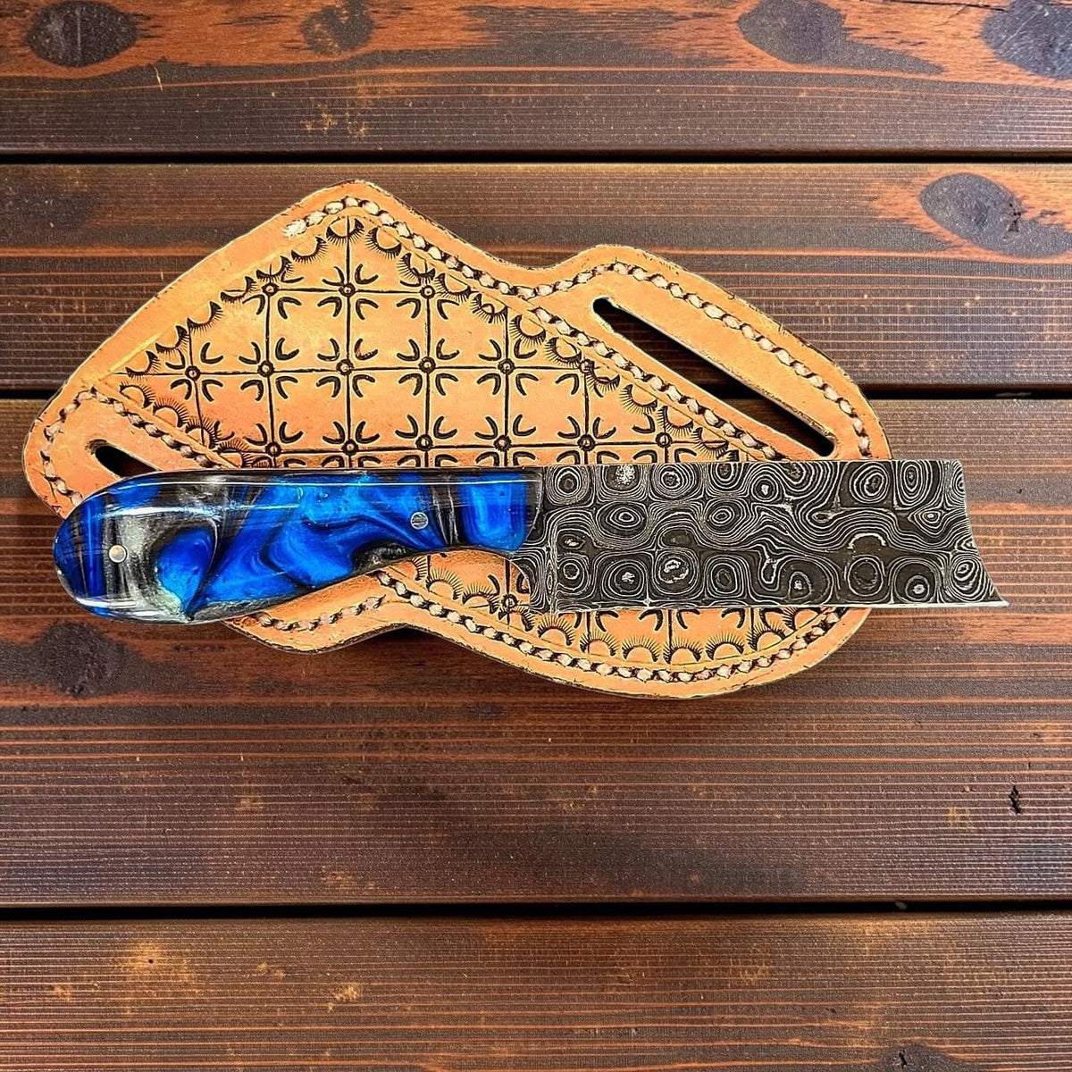 The Thunderhead knife by Frontier Cowboy Gear with blue epoxy handle and raindrop Damascus blade on Tampa Home & Garden Store