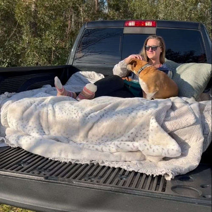 Umbrauto 6ft Isuzu truck bed air mattress in a pickup with soft blankets and a person with dog on Tampa Home & Garden Store