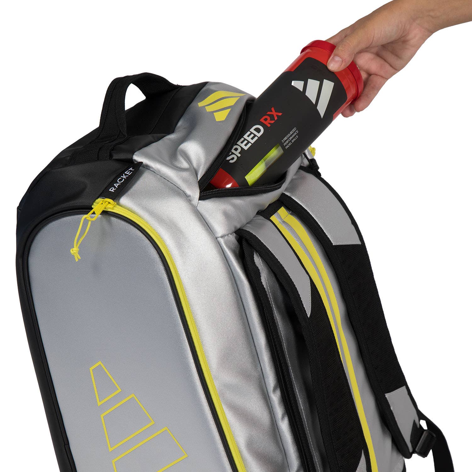 Adidas Padel Tour Silver racket bag with yellow zippers; hand inserts red Speed RX bottle on Tampa Home & Garden Store