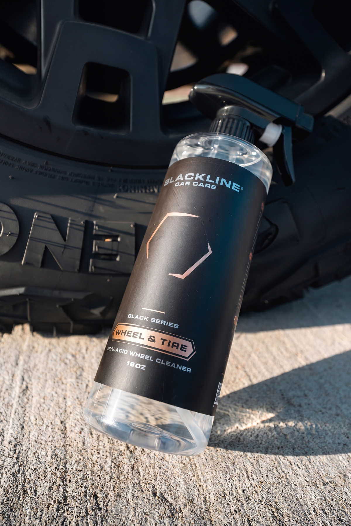BLACKLINE WHEEL N' TIRE CLEANER bottle with black label near a wheel rim Blackline Car Care on Tampa Home & Garden Store