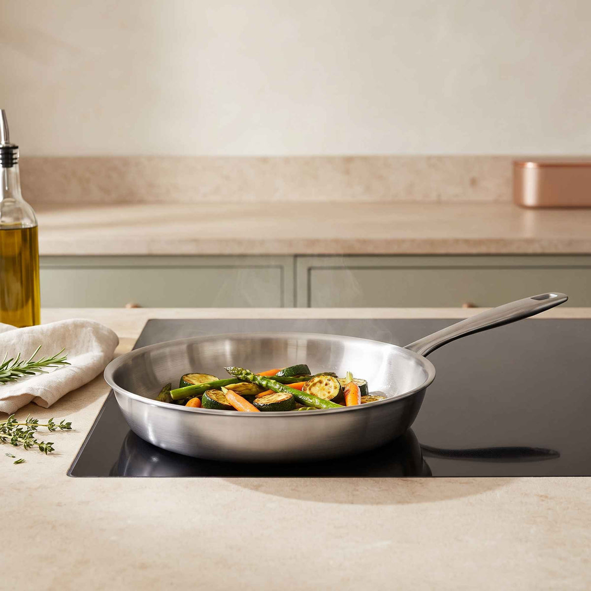 Alva Cookware 5-ply stainless steel frying pan with vegetables on induction cooktop on Tampa Home & Garden Store