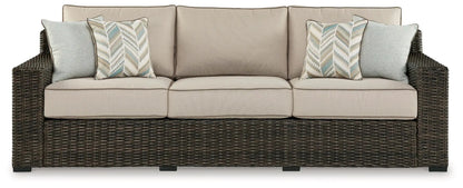 Coastline Bay sofa with beige cushions, dark wicker frame and blue chevron pillows on Tampa Home & Garden Store