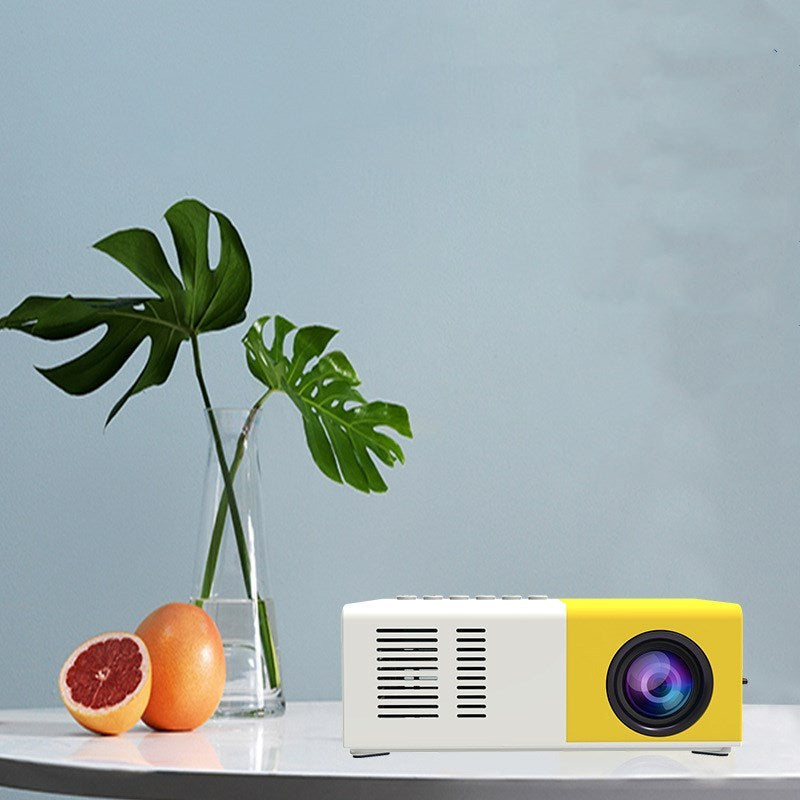 Handheld mini LED projector white-yellow, Sell My Stuff projector on table with citrus fruits on Tampa Home & Garden Store